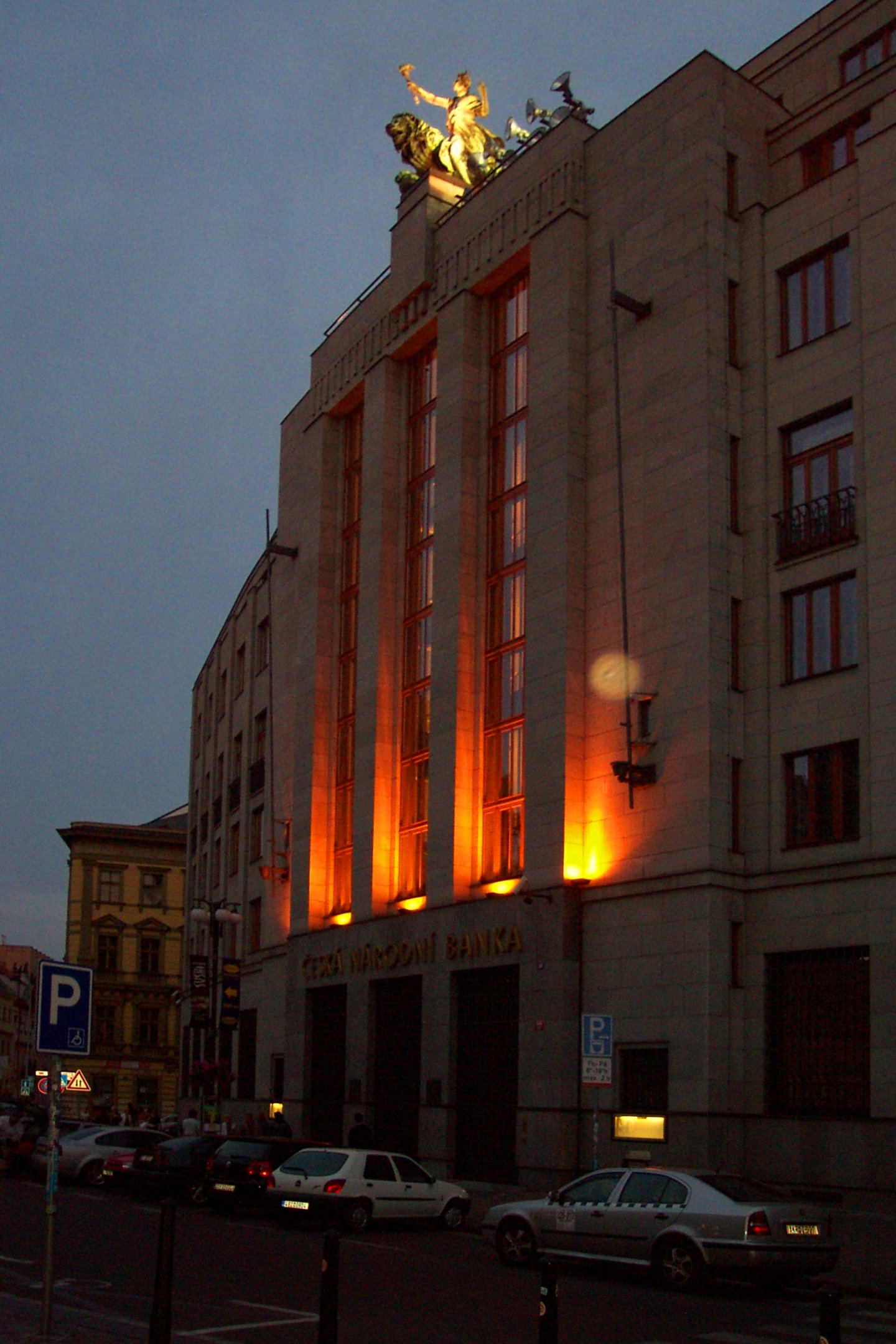 Czech National Bank building illuminated at dusk in Prague