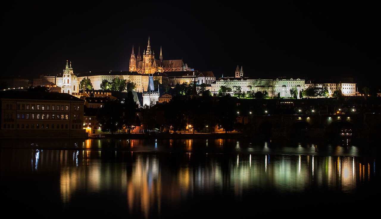 Pražský hrad osvětlený v noci nad Vltavou.
