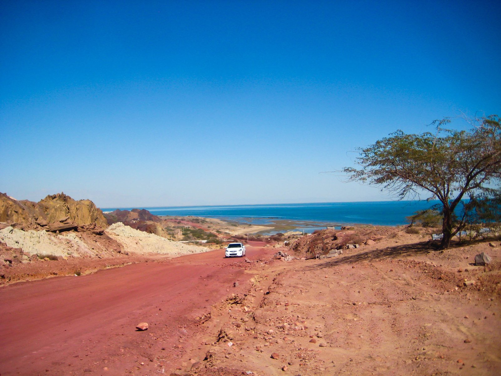 Red soil road on Hormuz Island, Iran, with the Persian Gulf in the background