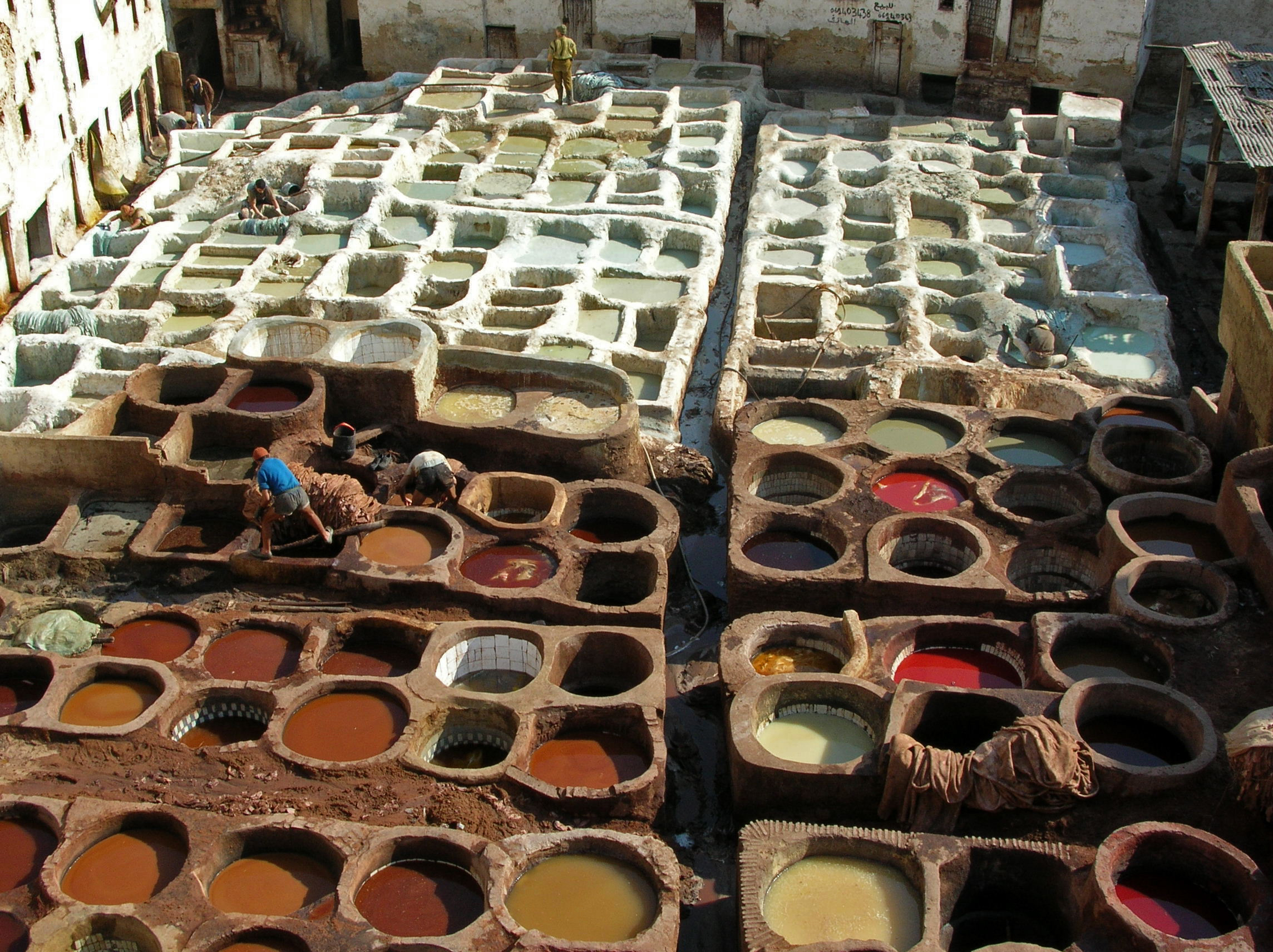 Aerial view of the Chouara Tannery in Fes, colorful round stone dye vats arranged in a grid