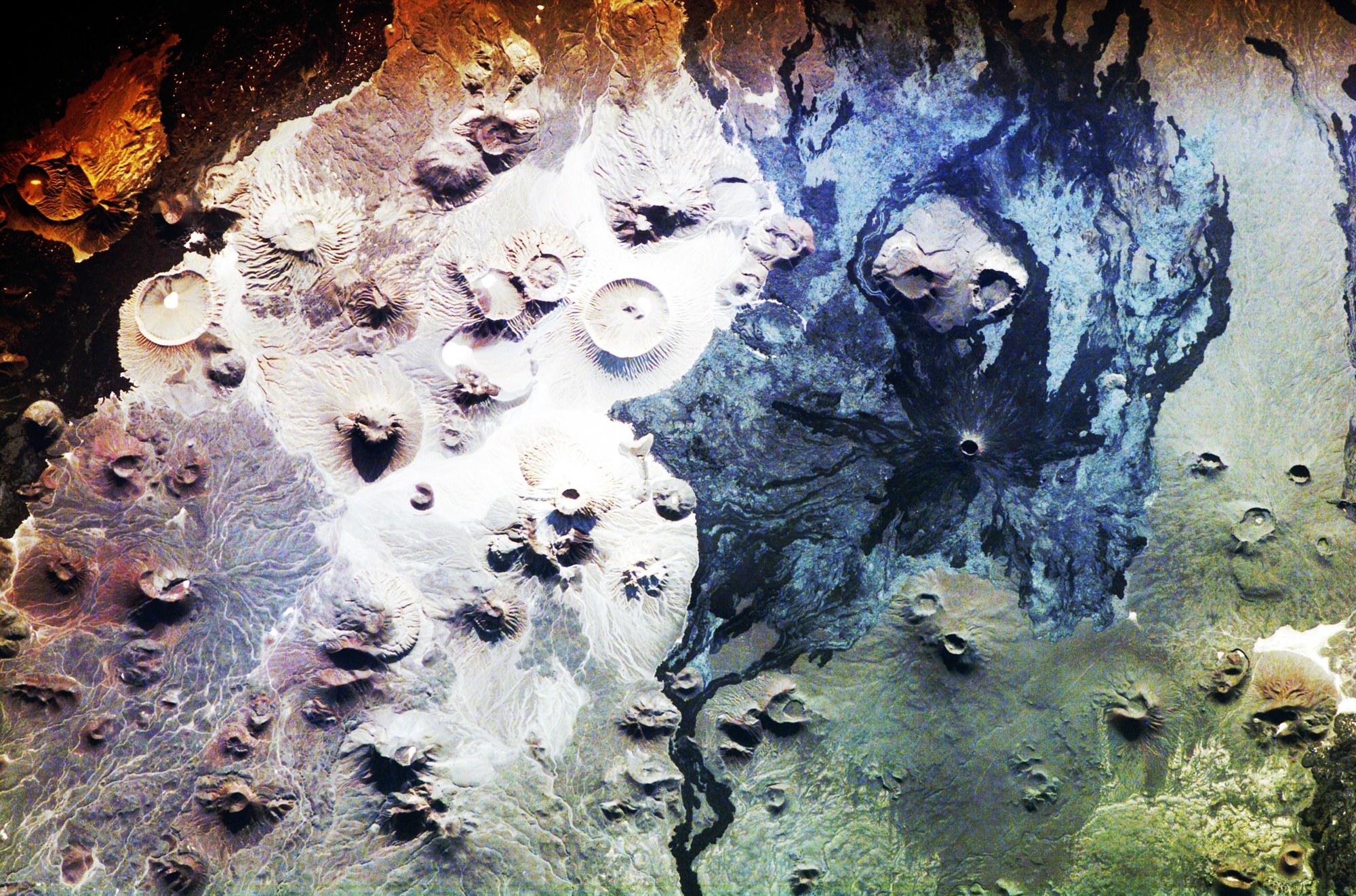 Harrat Khaybar's pale white volcanic cones against dark basalt fields, satellite view